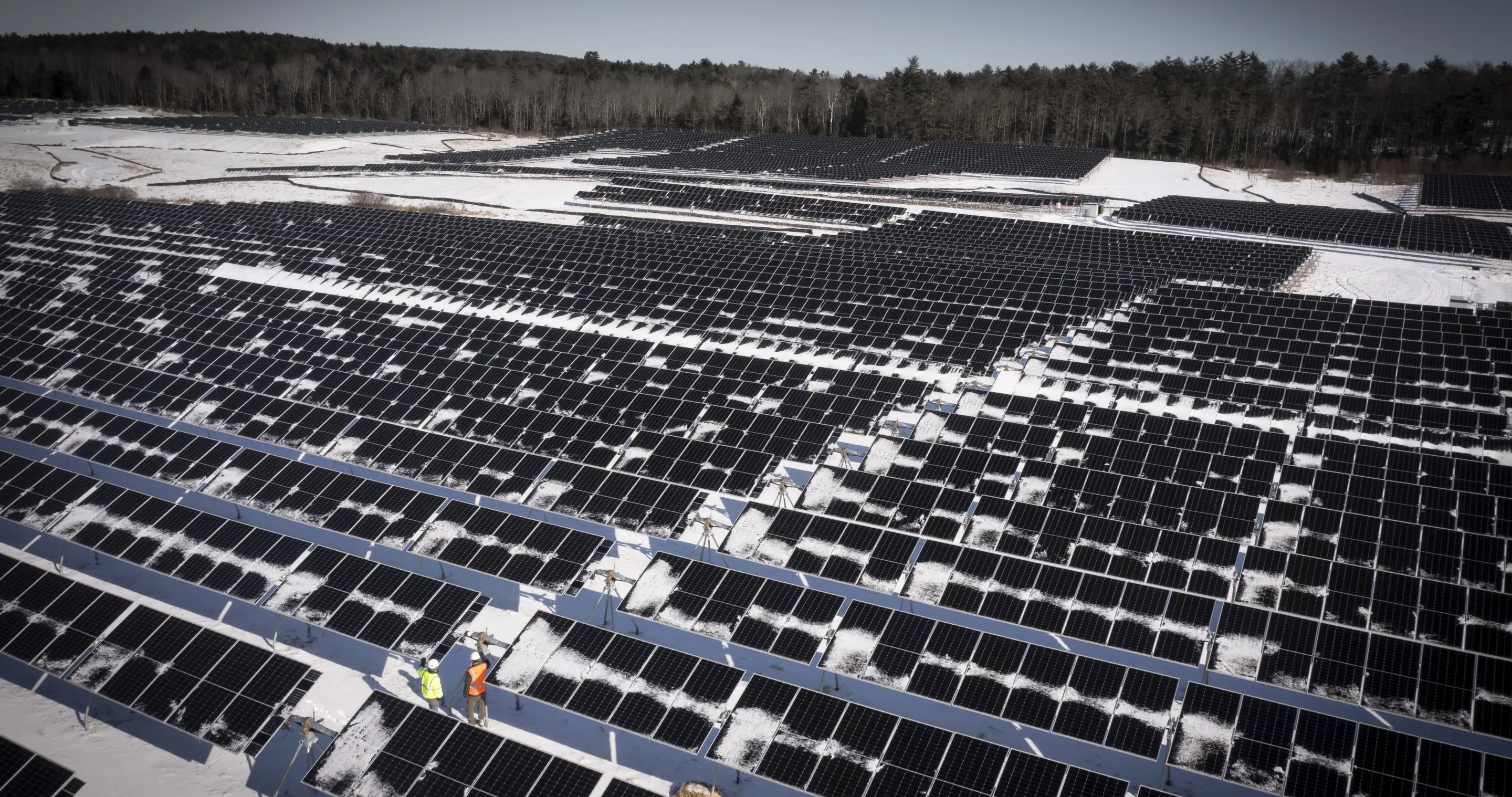 Aerial view of a Louth Callan array under snow with crew working between the rows.